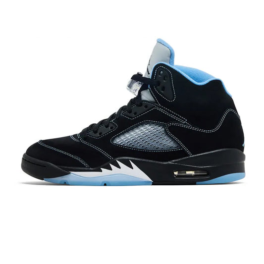 Lateral profile view of the Jordan 5 Retro Black University Blue sneaker featuring a black suede upper with blue contrast stitching, clear mesh side panel, silver 3M tongue, white shark-tooth midsole details, and an icy blue translucent outsole.