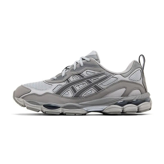 Lateral profile view of the ASICS GEL-NYC RGD Cement Grey sneaker featuring a tonal grey mesh and synthetic upper, grey midsole, dark charcoal GEL pods, and rugged construction.