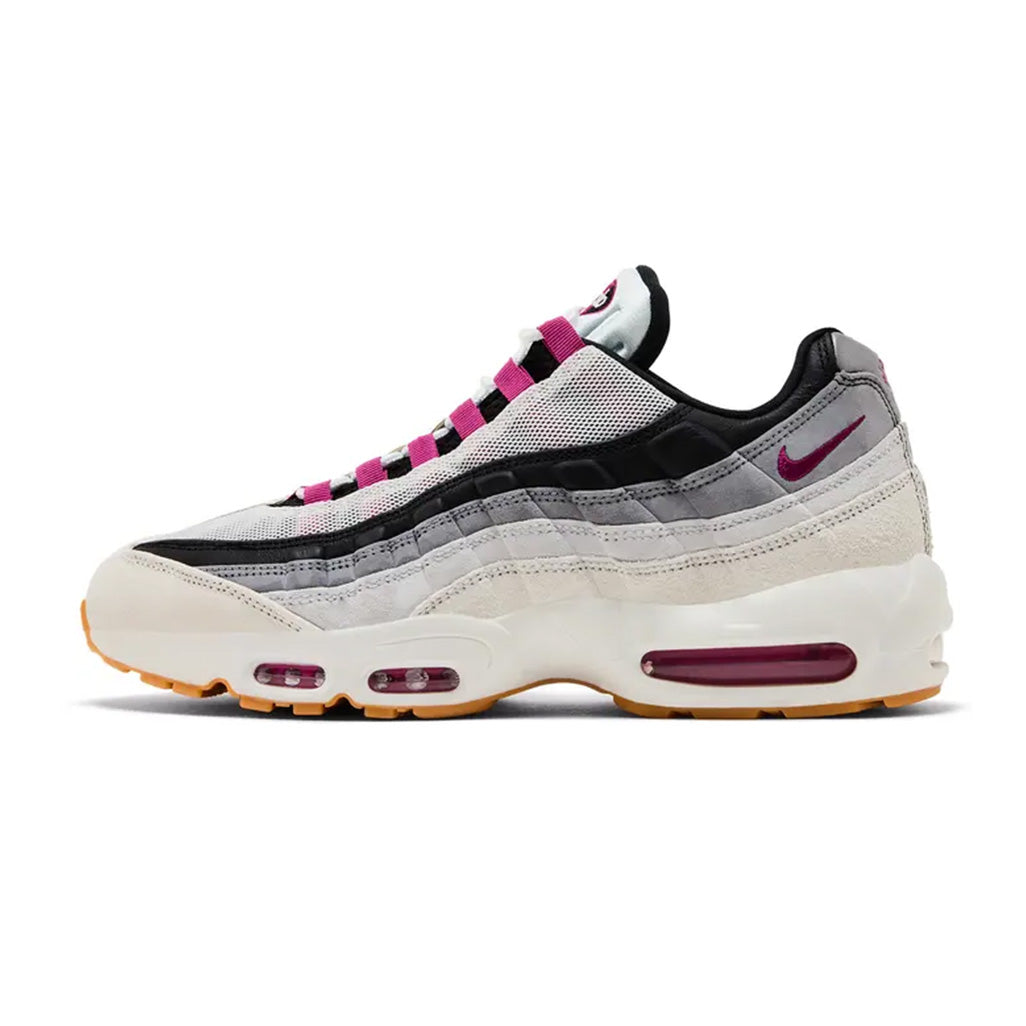 Lateral profile view of the Nike Air Max 95 Cactus Flower sneaker featuring a graduated grey and white upper, vibrant pink lace loops, pink heel Swoosh, white midsole with pink Air units, and a gum rubber outsole.
