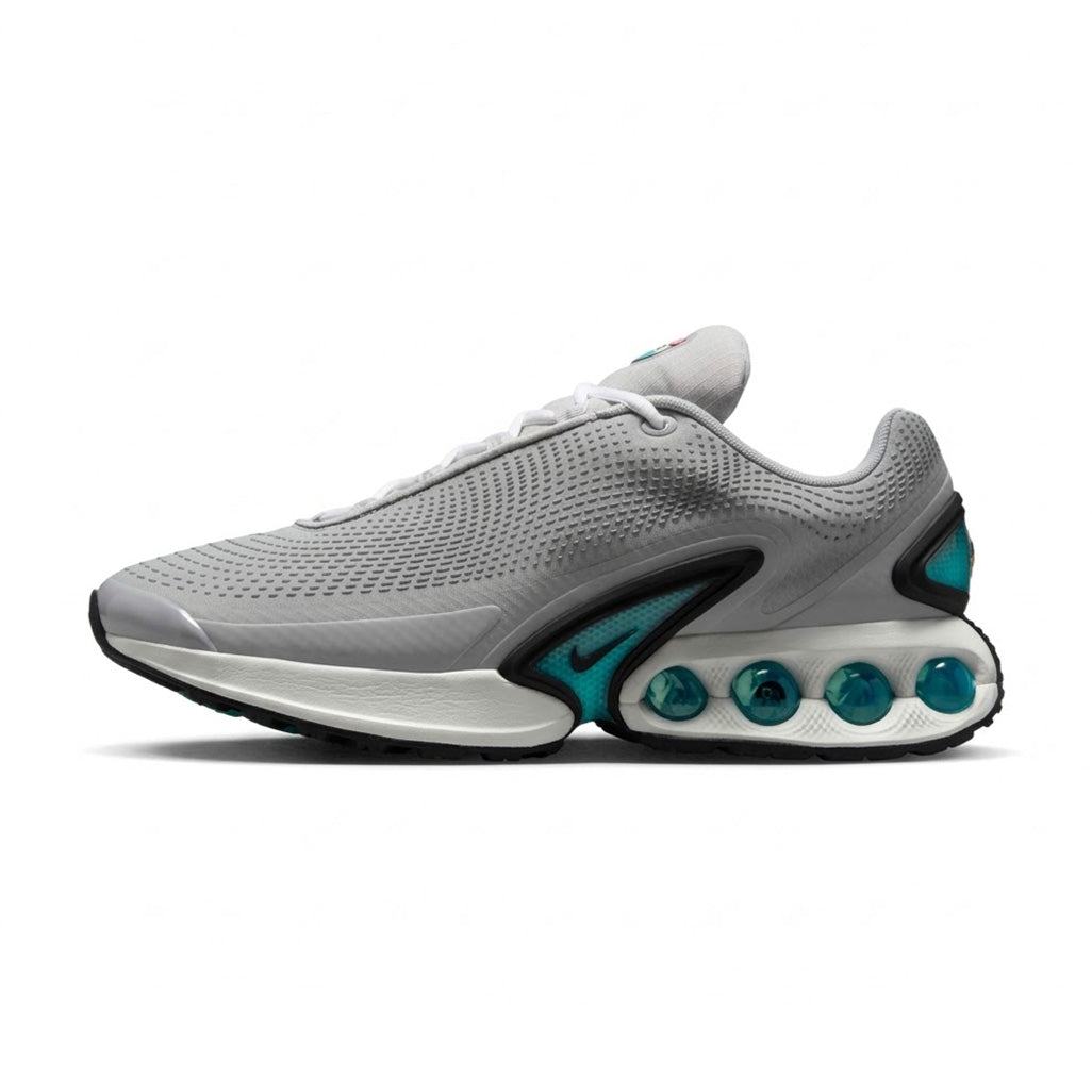 Lateral side view of the Nike Air Max Dn Pure Platinum Hyper Royal sneaker featuring a pure platinum grey textured mesh upper, white midsole, teal midfoot TPU clip with a mini Swoosh, and translucent teal tubed Dynamic Air units in the heel.