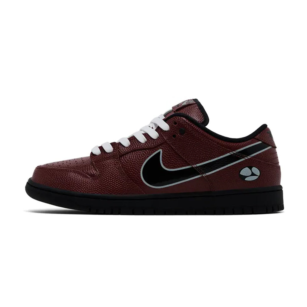 Lateral profile view of the Nike SB Dunk Low Limosine Skateboards sneaker featuring a burgundy tumbled leather upper, black Swoosh, white laces, solid black midsole, and a branded logo graphic near the heel.