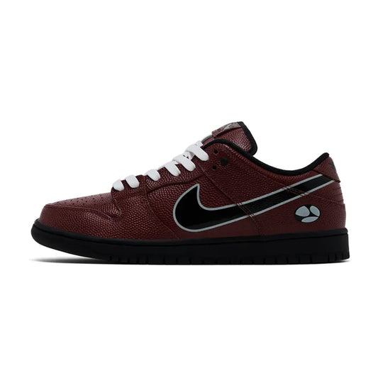 Lateral profile view of the Nike SB Dunk Low Limosine Skateboards sneaker featuring a burgundy tumbled leather upper, black Swoosh, white laces, solid black midsole, and a branded logo graphic near the heel.