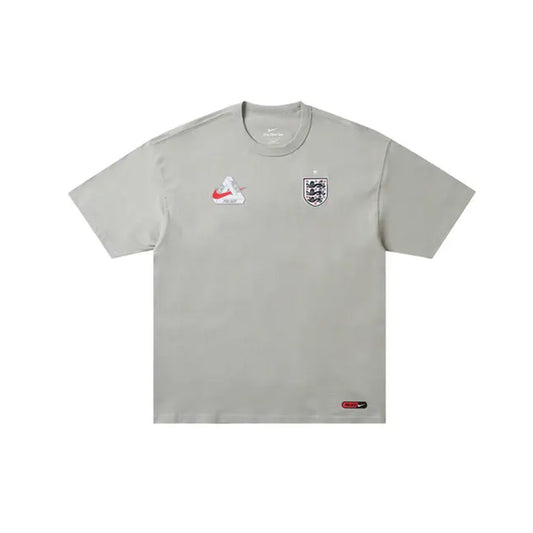 Back view of the Palace x Nike England T-Shirt in Pewter Grey showcasing a large white Tri-Ferg logo overlaid with three bright red lions, a red star above, and a red Nike Swoosh below.